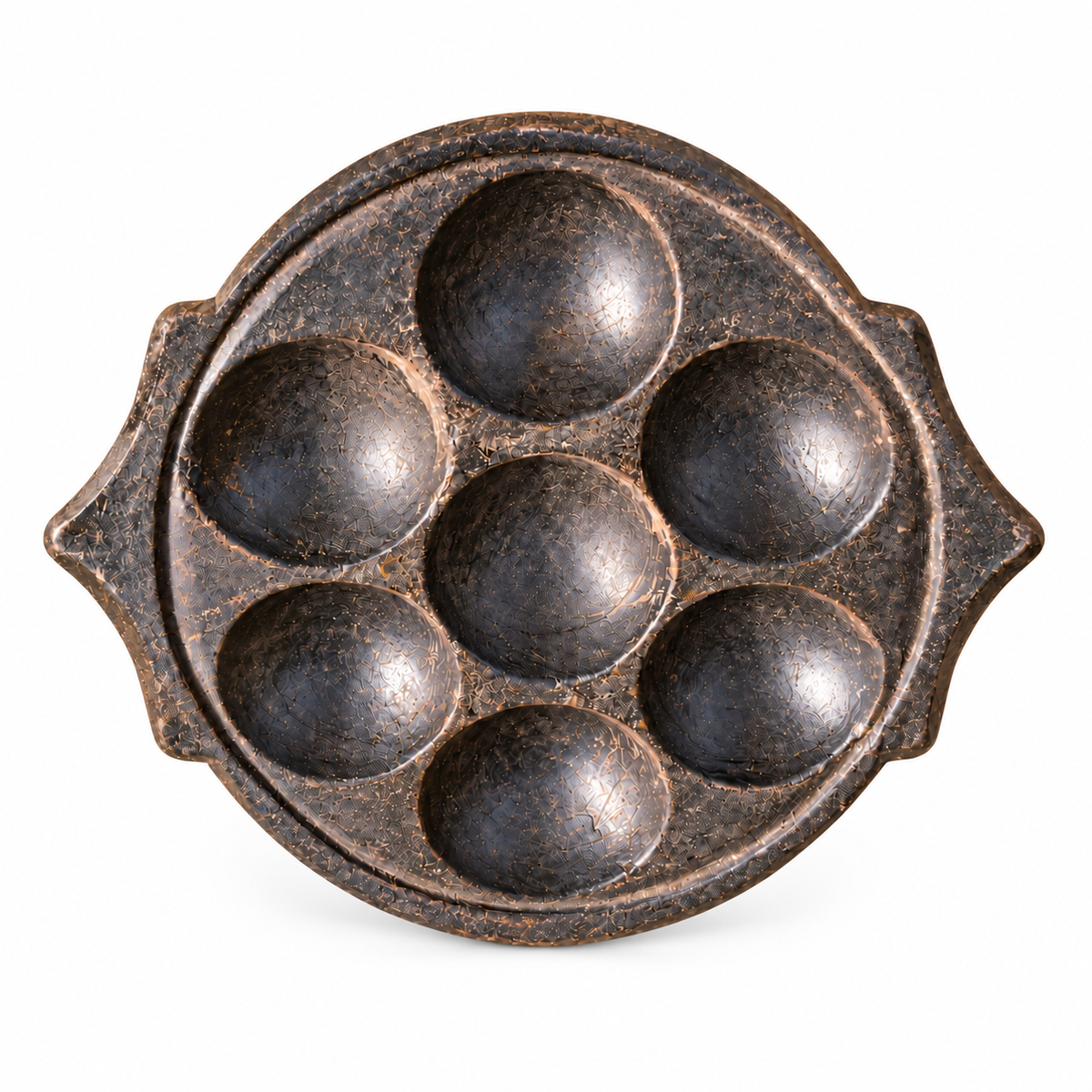 South-Indian-stone- idli-mould with seven rounded wells and pointed side handles on a white background