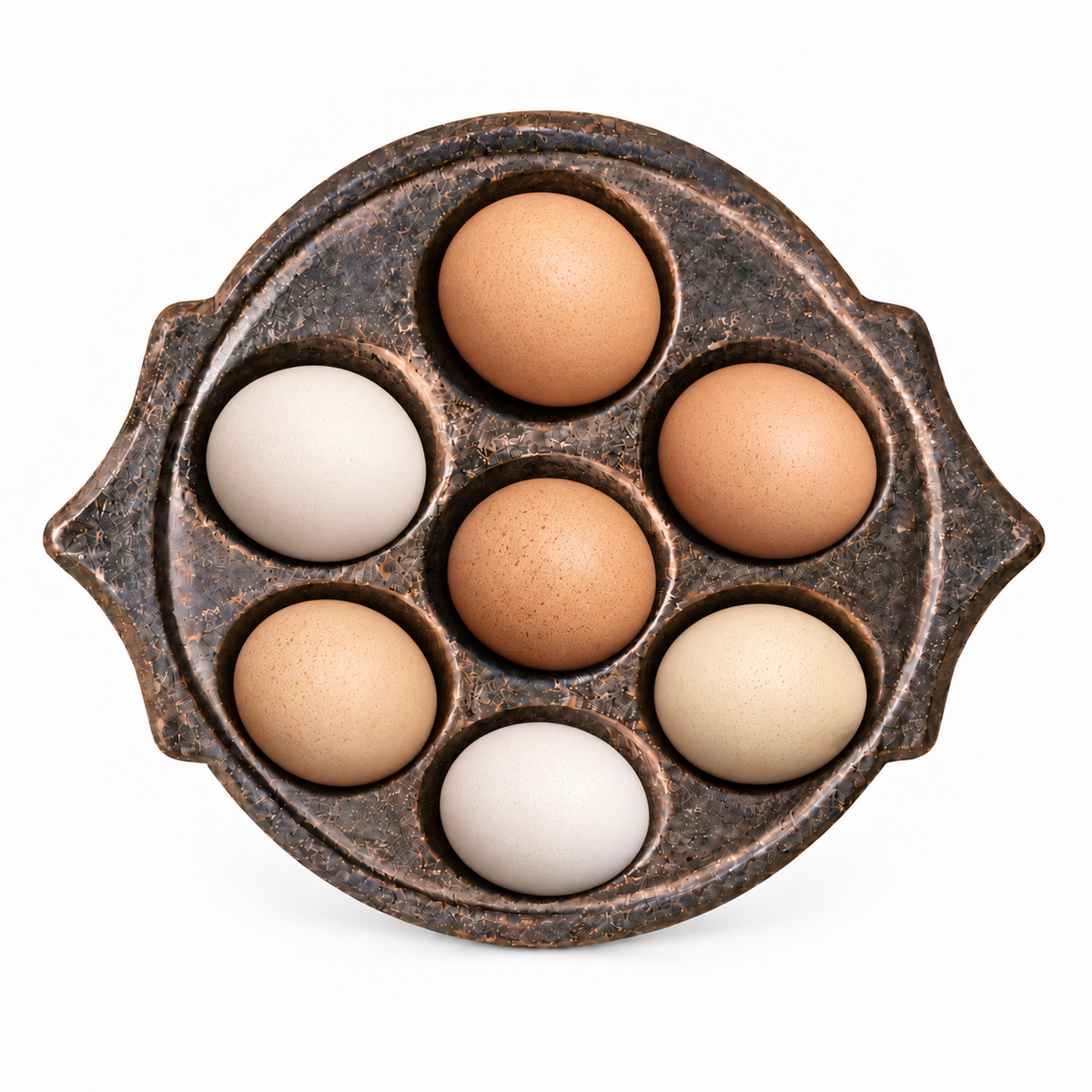 South Indian stone idli mould displaying seven brown and white eggs on a white background
